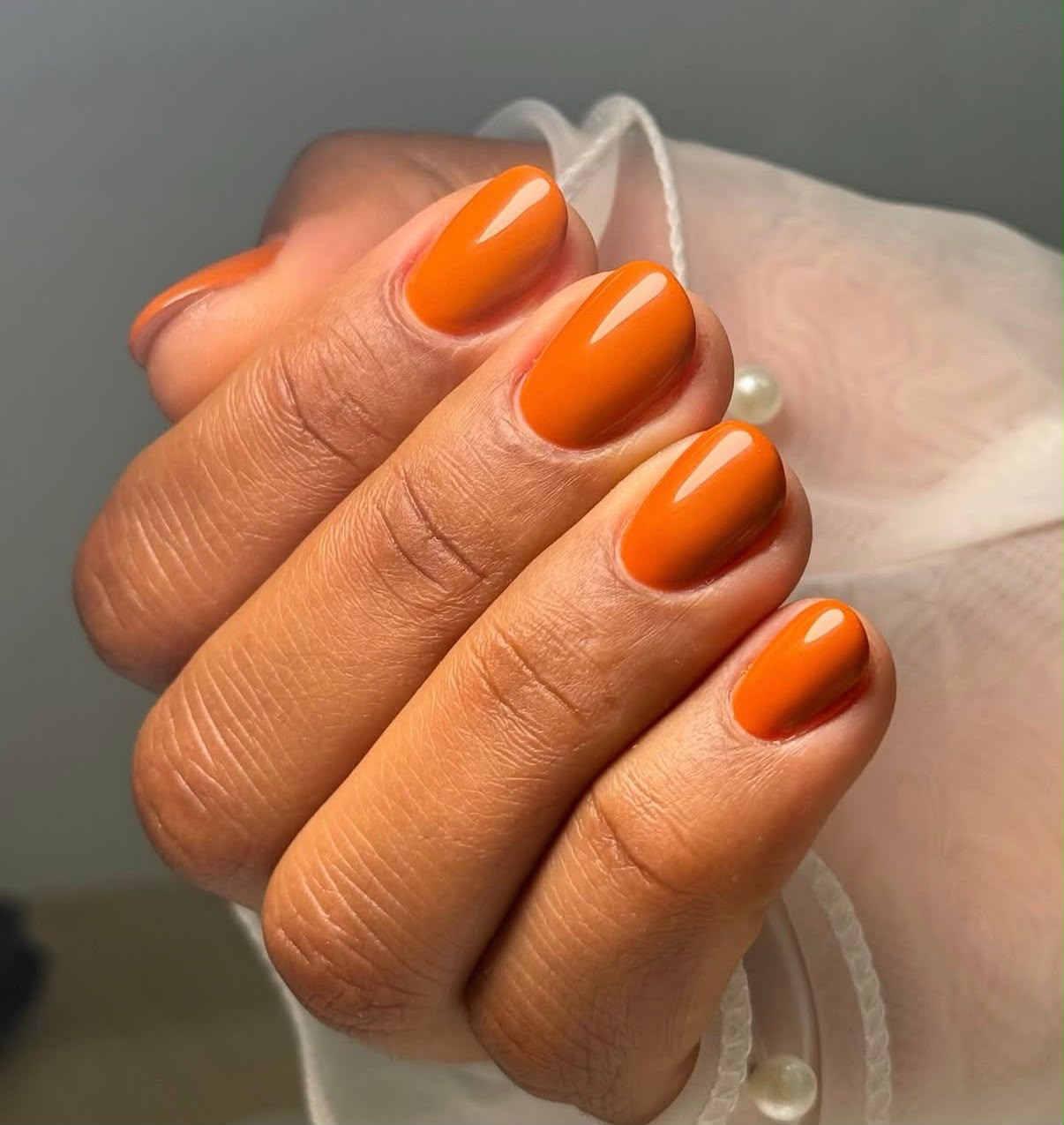 Trabalho da Sheron com unhas nude e brilho perolado